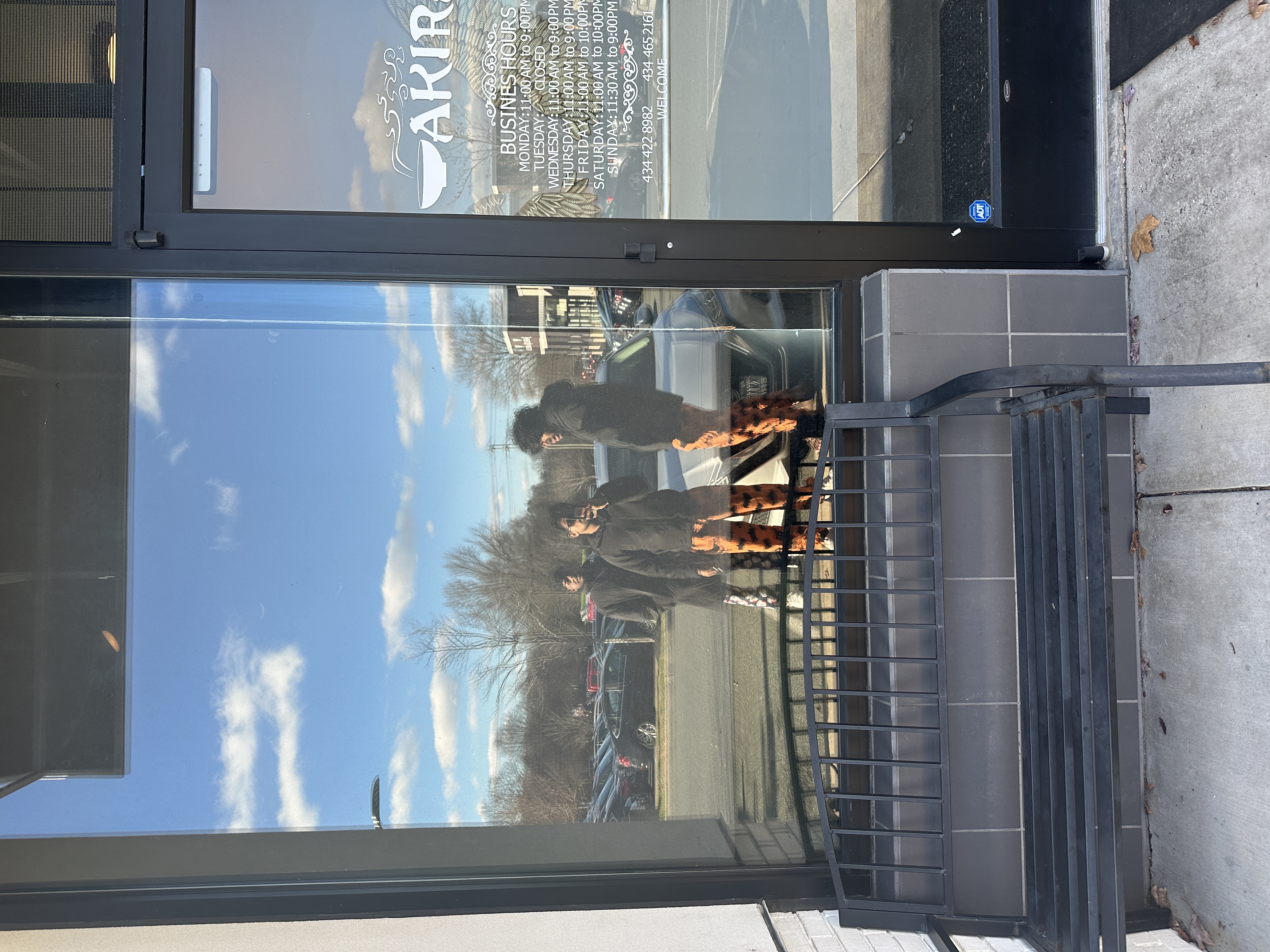 Friends hanging out in front of a restaurant with the car